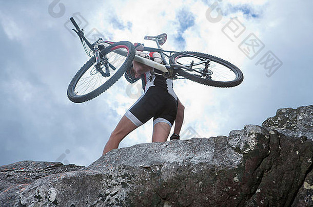 年轻的男人。携带山自行车前岩石