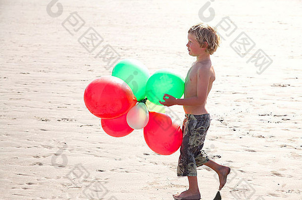 男孩海滩持有气球威尔士