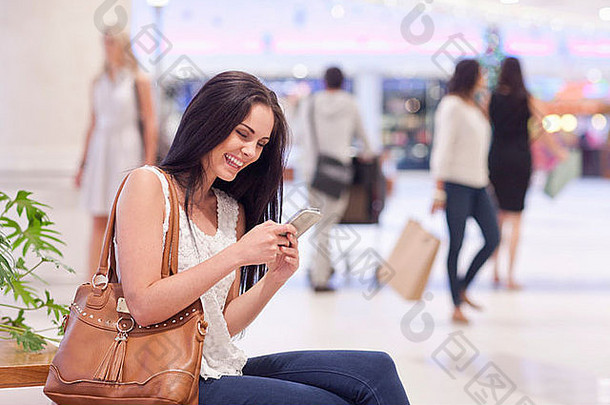 年轻的女人细胞电话购物中心