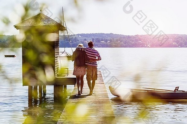 后视图年轻的夫妇走码头湖船库schondorf阿默西巴伐利亚德国
