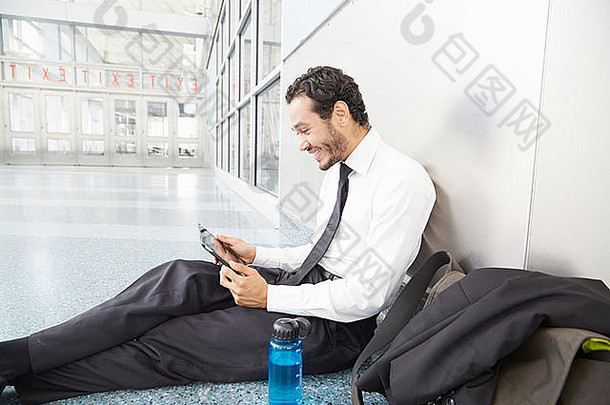 商人坐着地板上数字平板电脑