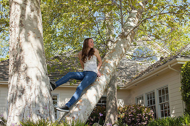 十几岁的女孩坐着树