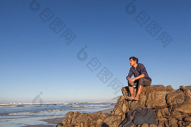 男人。坐着岩石海边
