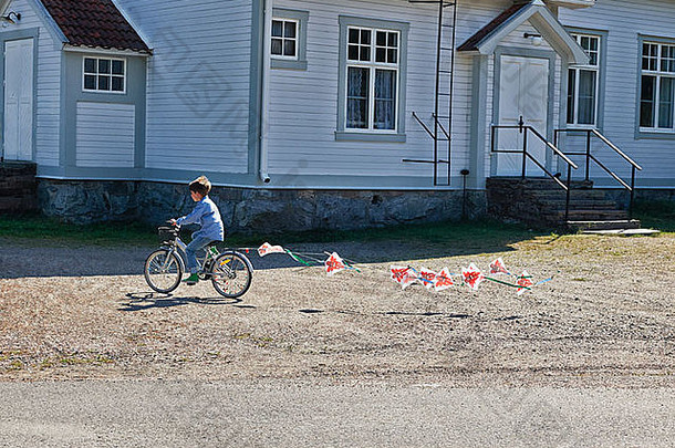 男孩骑自行车拉彩旗