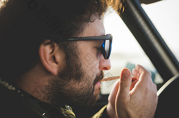 关闭中期成人男人。车照明香烟
