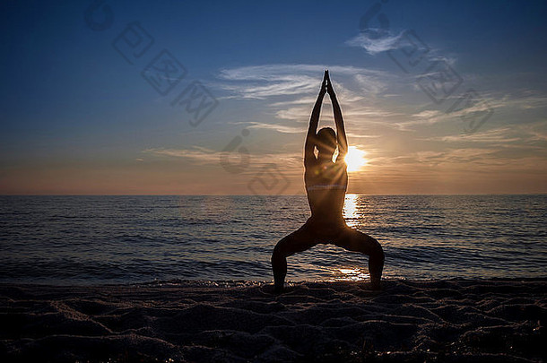 的轮廓年轻的女人练习瑜伽海滩日落里斯塔诺撒丁岛意大利