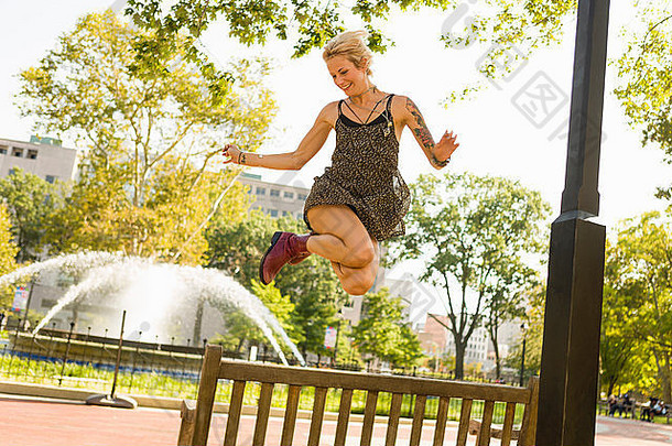年轻的女人跳中期空气公园