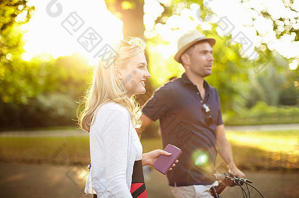 夫妇自行车漫步阳光照射的公园