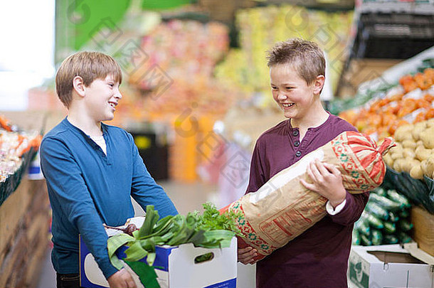 年轻的男孩携带蔬菜室内市场