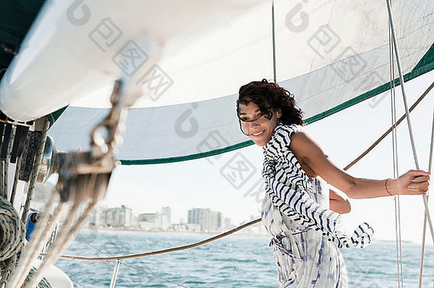 年轻的女人游艇穿条纹围巾