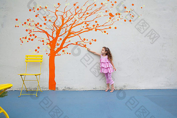 女孩指出橙色树壁画墙