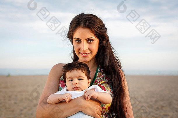 关闭妈妈。站海滩持有婴儿