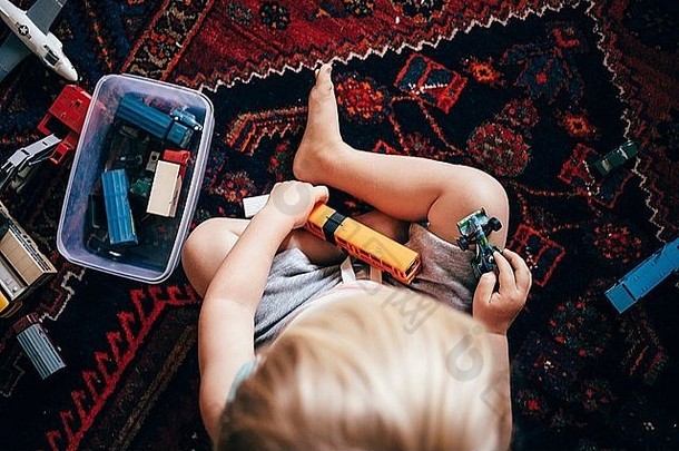 开销视图男孩坐着地毯玩玩具火车