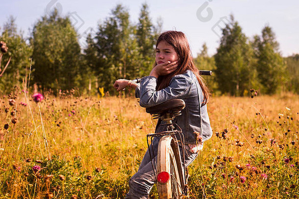 十几岁的<strong>女孩</strong>坐着自行车长长满草的场