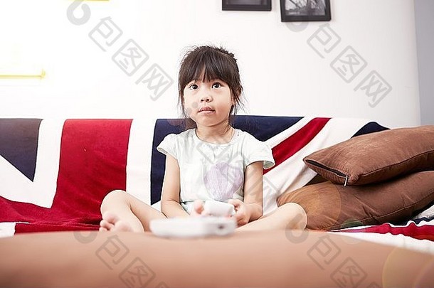 年轻的女孩坐着沙发看电视首页