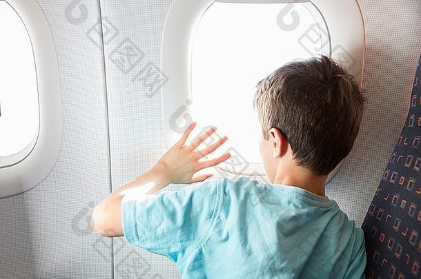 后视图男孩挥舞着飞机窗口