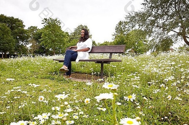 成熟的女人坐着板凳上黛西填满公园