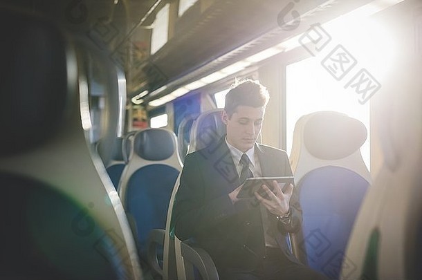 肖像年轻的商人通勤数字平板电脑火车