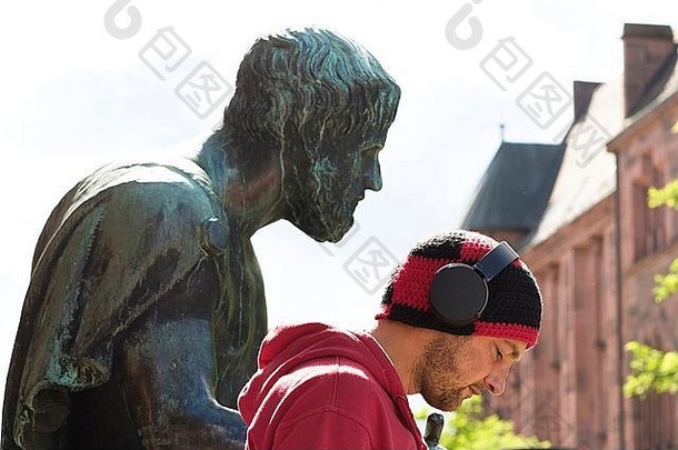头肩膀肖像中期成人男人。穿耳机前面雕塑弗莱堡巴登德国
