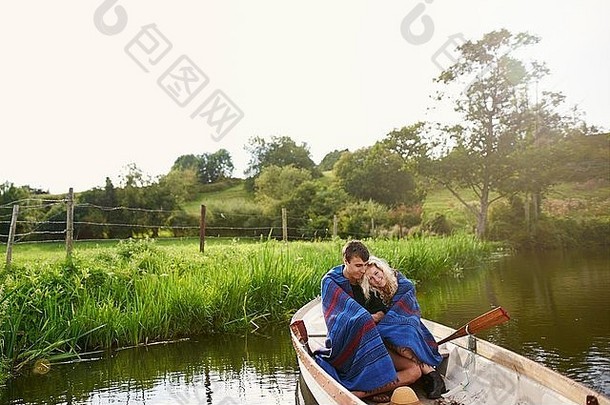 年轻的夫妇包装挤毯子河划船船