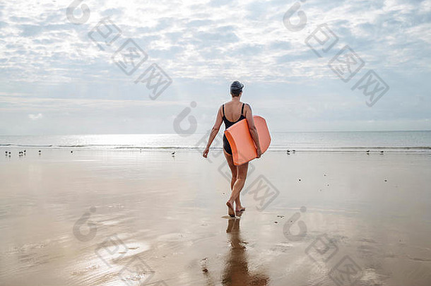 女人携带冲浪板海滩福克斯顿