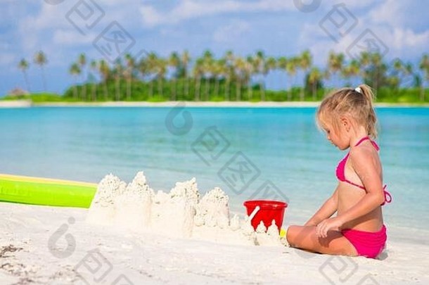 可爱的女孩玩海滩玩具热带假期