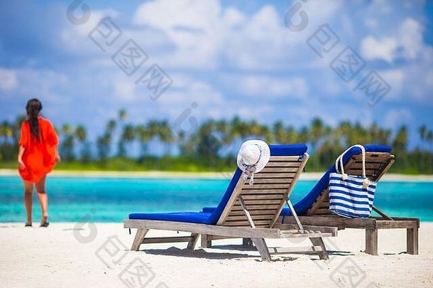 美丽的年轻的女人放松海滩椅子