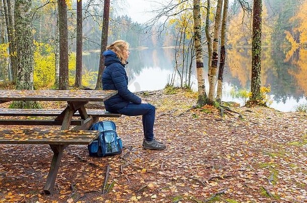 女人坐在野餐表格芬兰自然