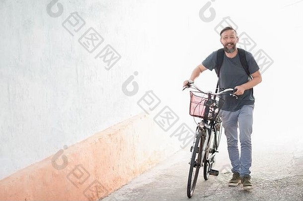 赶时髦的人男人。背包推复古的自行车