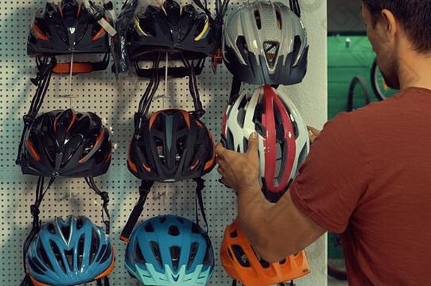 年轻的高加索人男人。站站自行车商店头保护部门选择自行车头盔