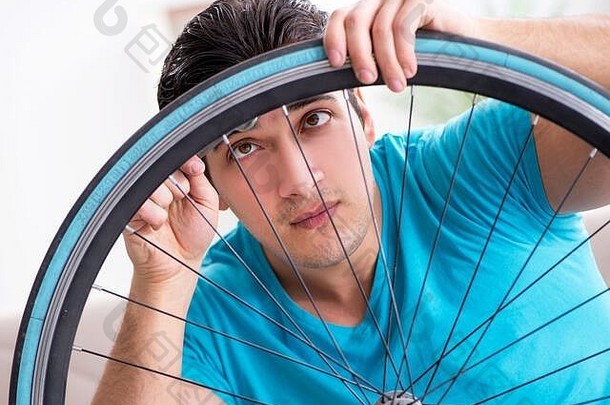 年轻的男人。修复自行车<strong>首页</strong>