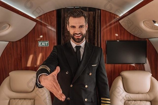 英俊的飞行员微笑相机站伸出的手