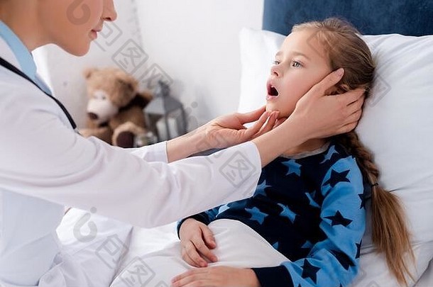 医生白色外套检查生病的孩子打开口