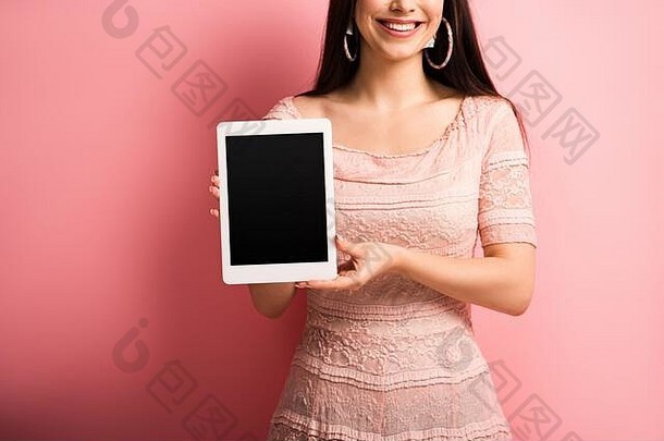 裁剪视图微笑女孩显示数字平板电脑空白屏幕粉红色的背景