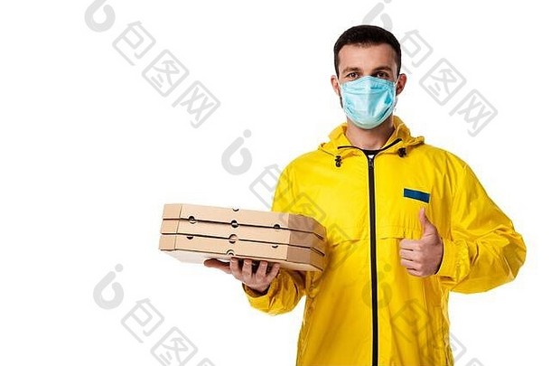 交付男人。医疗面具持有披萨盒子显示拇指孤立的白色