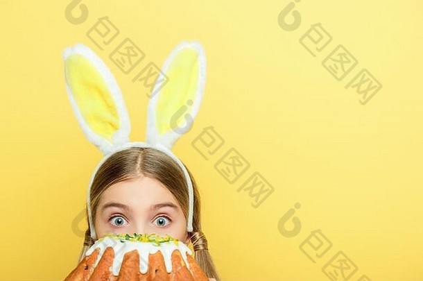 震惊了孩子兔子耳朵覆盖脸复活节蛋糕孤立的黄色的