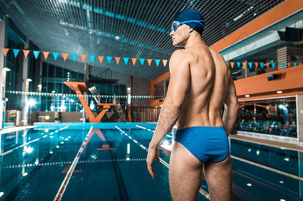 回来视图肌肉发达的游泳运动员游泳帽护目镜站游泳池
