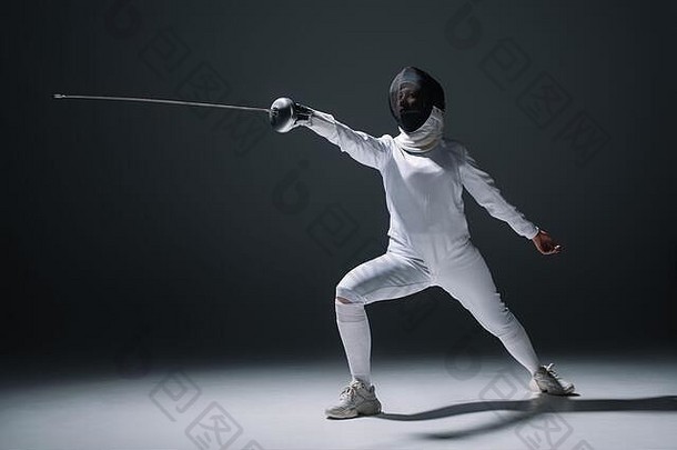 经验击剑面具西装持有剑杆白色表面黑色的背景
