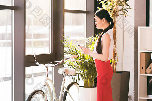 有吸引力的亚洲女商人工作智能手机办公室自行车站