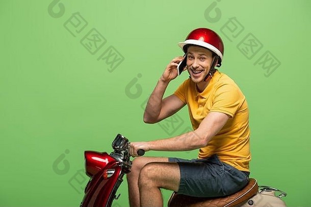 一边视图快乐交付男人。黄色的统一的会说话的智能手机踏板车孤立的绿色