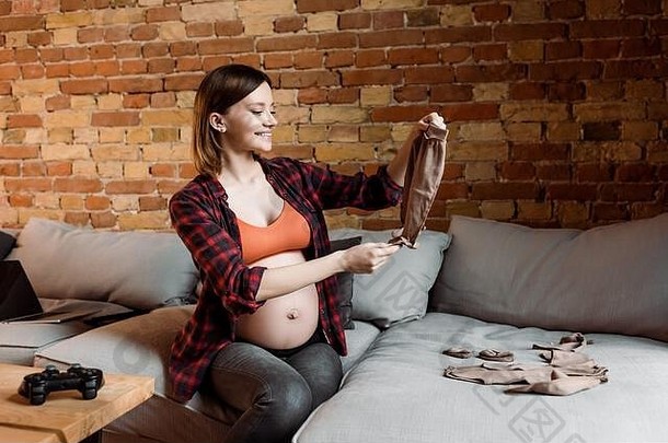基辅乌克兰4月快乐的怀孕了女人持有婴儿裤子操纵杆表格