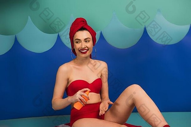 快乐女人红色的毛巾泳衣应用防晒霜纸减少波