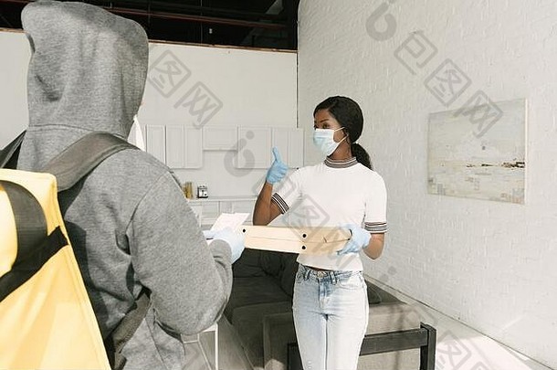 非洲美国女孩<strong>医疗</strong>面具乳胶手套采取盒子披萨交付男人。
