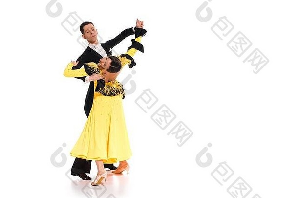 优雅的年轻的夫妇舞厅舞者黄色的衣服黑色的西装跳舞白色