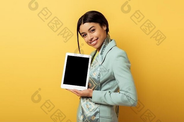 快乐非洲美国女人持有数字平板电脑空白屏幕黄色的