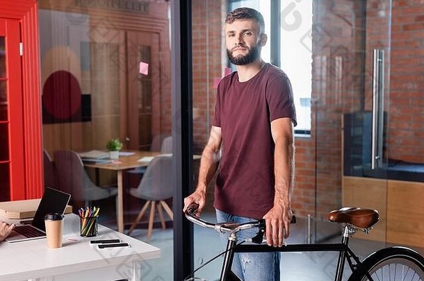 有胡子的商人站自行车现代办公室