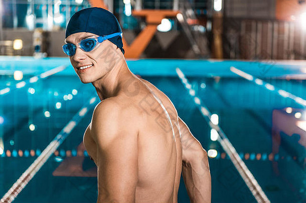 英俊的肌肉发达的游泳运动员游泳帽护目镜
