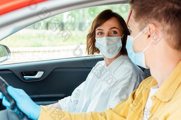 男人。女人医疗面具保护手套坐着车科维德流感大流行