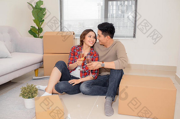 特写镜头拍摄快乐的亚洲夫妇无比的<strong>酒</strong>眼镜坐着地板上公寓