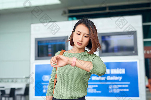 美丽的亚洲女人手表检查时间